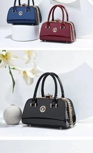 Detail of luxury patent leather handbags with rhinestone clasps and gold chain decor