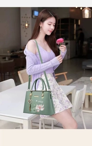 Detail der grünen chinesischen Lotus-Sticktasche mit Herz-Quaste im Café-Stil