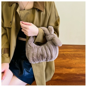 Detail of soft plush faux fur handbag with rabbit ear handle and pleated texture