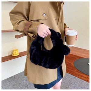 Detailed close-up of a black fluffy faux fur handbag with a soft cloud-like texture