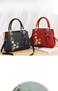 Close-up of elegant floral embroidery and 3D bow charm on leather handbags