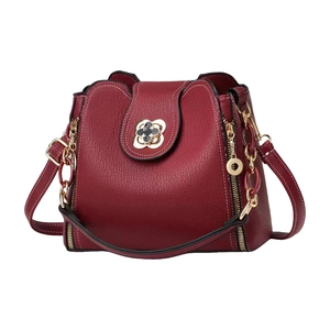 Sac bandoulière en cuir bordeaux avec trèfle doré et chaîne sur fond blanc immaculé