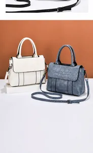 Detalle de bolsos elegantes de piel con grabado de cocodrilo en beige y azul con correa larga