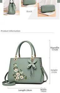 Detail view of green floral embroidery handbag with clover charm and dimensions