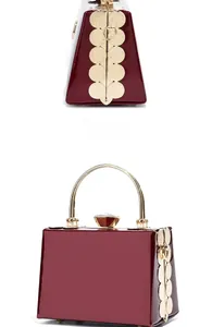 Detailed side and perspective views of wine red glossy evening bag with gold handles