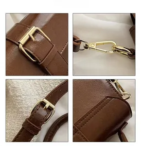 Detailed close-up of brown leather texture and golden metal buckle on vintage shoulder bag
