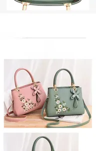 Detail of pink and green handbags featuring floral embroidery and decorative bow charms