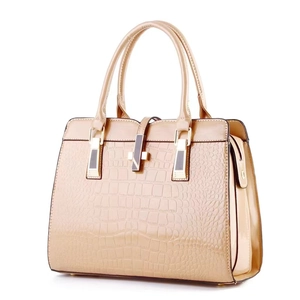 Detail of champagne gold handbag showing faux crocodile texture and gold hardware