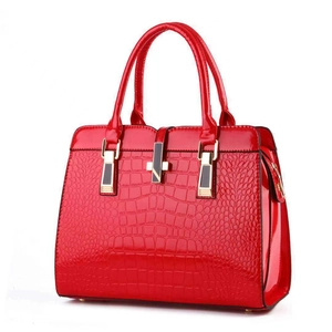 Macro detail of glossy red crocodile texture on large office tote bag surface