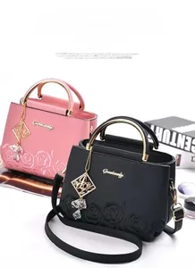 Détail de la texture rose brodée sur sacs seaux en cuir rose et noir à anses dorées