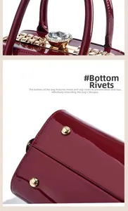 Detail of burgundy patent leather bag with crystal closure and gold bottom studs