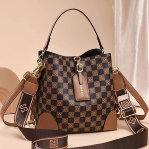 Detail der karierten Beuteltasche mit floralen Motiven und Logo-verziertem Schultergurt