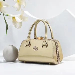 Elegant champagne gold glossy handbag with luxury gemstone clasp and metal chain detail