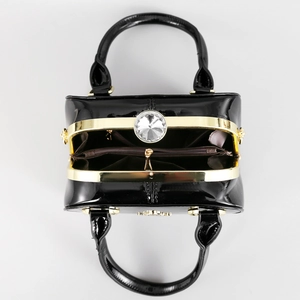 Top view of patent leather handbag with gold frame and large crystal clasp detail
