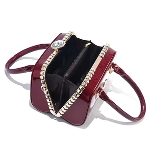 Elegant wine red patent leather evening bag with diamond clasp and interior compartments