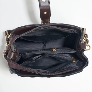 Top view of deep brown bucket bag showing multi-compartment interior and gold zippers
