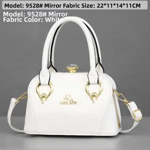 White glossy patent leather bag with gold hardware and size dimensions for scale