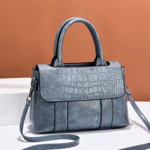 Bolso bandolera azul grisáceo con solapa de cocodrilo y asas superiores redondas