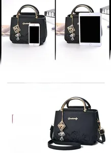 Détail d'un sac seau en cuir noir avec gaufrage rose et poignée en métal doré chic