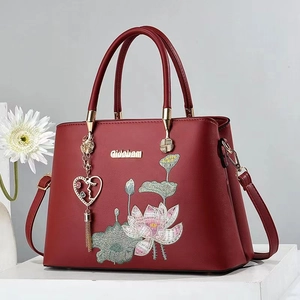 Elegante weinrote Handtasche mit Lotus-Stickerei und Metallquaste in der Anzeige