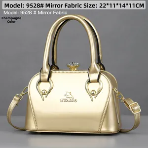 Detail of champagne gold mirror leather bag with rhinestone clasp and metal logo