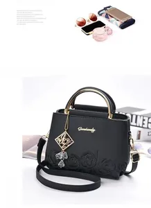 Détail du sac seau noir avec texture litchi, gaufrage rose et poignée dorée