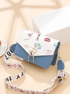 Blue and white color-block crossbody bag with travel prints and pearl cat-ear charm