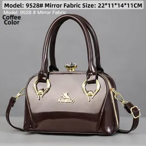 Macro detail of glossy coffee mirror leather handbag with gold metal hardware and logo