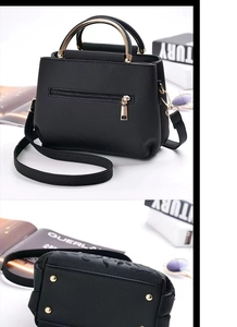 Détail du sac seau en similicuir noir avec poignée anneau doré et clous de protection