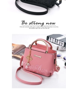 Détail du sac seau rose avec broderie florale et logo de marque en métal doré