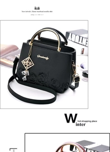 Détail du sac seau noir avec gaufrage rose, poignée dorée et pompon élégant