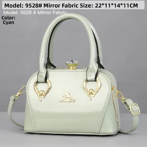 Detail of mint green glossy handbag with gold metal logo and crystal lock buckle