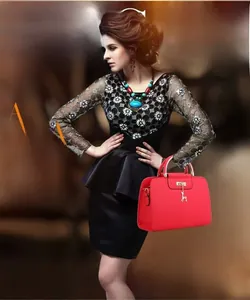 Detail of red quilted PU leather handbag featuring a golden deer charm and cylinder hardware