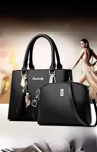 Vue détaillée du set de sacs en cuir noir texturé avec pendentif chat doré et pompon chic