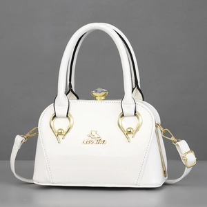 White patent leather handbag with gold cat logo and crystal clasp for elegant evening use
