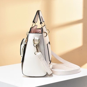 Vue latérale d'un sac à main blanc avec bordure noire et détails dorés brillants