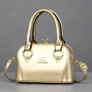 Golden metallic top-handle bag with logo and jewel clasp on grey background