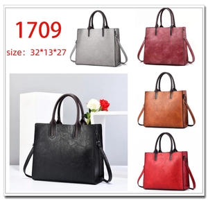 Detalle de bolso tote grande en cinco colores con textura de cuero y talla 32x13x27 cm