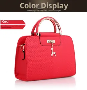 Detail view of red quilted PU leather handbag with gold handle and deer pendant