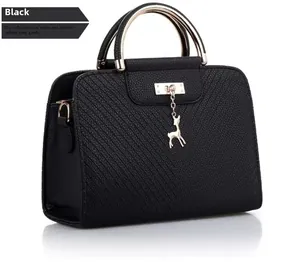 Detail of black pebbled PU leather handbag with gold metal handle and deer charm
