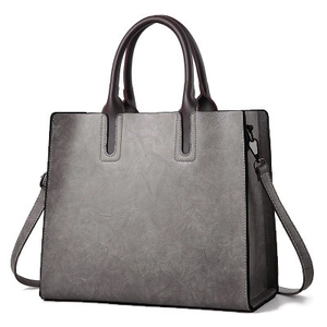 Bolso tote vintage gris oscuro con asas marrones y textura de cuero vista a 45 grados