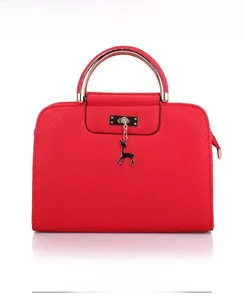 Detailed front view of red faux leather handbag with gold metal handle and deer charm