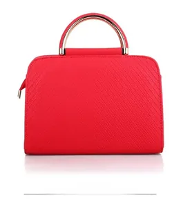 Back view of red textured leather handbag featuring golden metal handles and V-shaped quilting