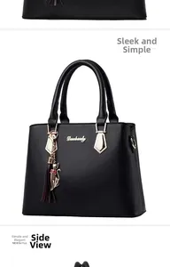 Détail du sac à main en cuir noir avec logo doré et pendentif pompon chat en métal