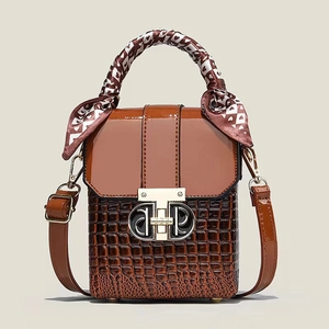 Détail du sac à main marron effet croco avec poignée en foulard et fermoir métal