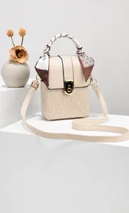Dettaglio mini borsa crema con trama a coccodrillo, chiusura oro e manico con foulard