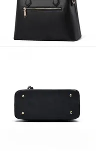 Détail du sac à main noir montrant la poche arrière zippée et les clous de fond dorés