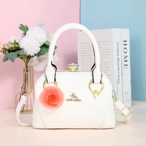 Détail du sac à main blanc en cuir avec logo doré et pendentif fleur de rose