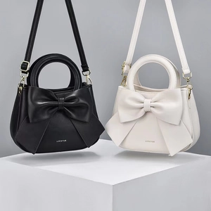 Détail du sac à main élégant montrant le grand nœud décoratif et les ferrures dorées