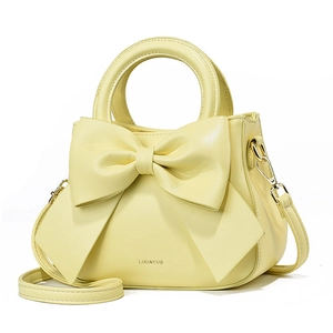 Détail du sac à main jaune clair avec nœud, finitions dorées et bandoulière en cuir